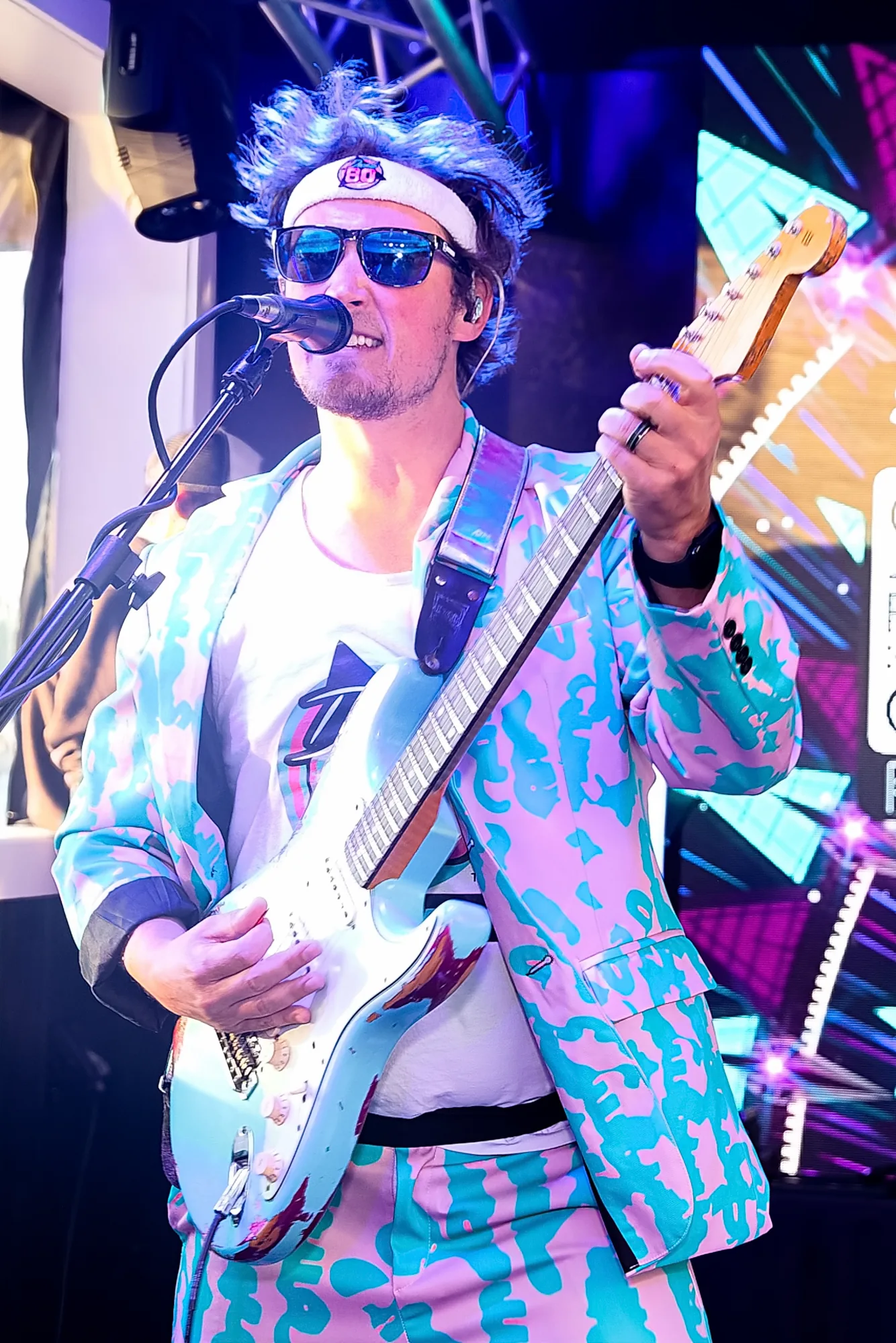 Decade80 guitarist in sunglasses and a pastel suit