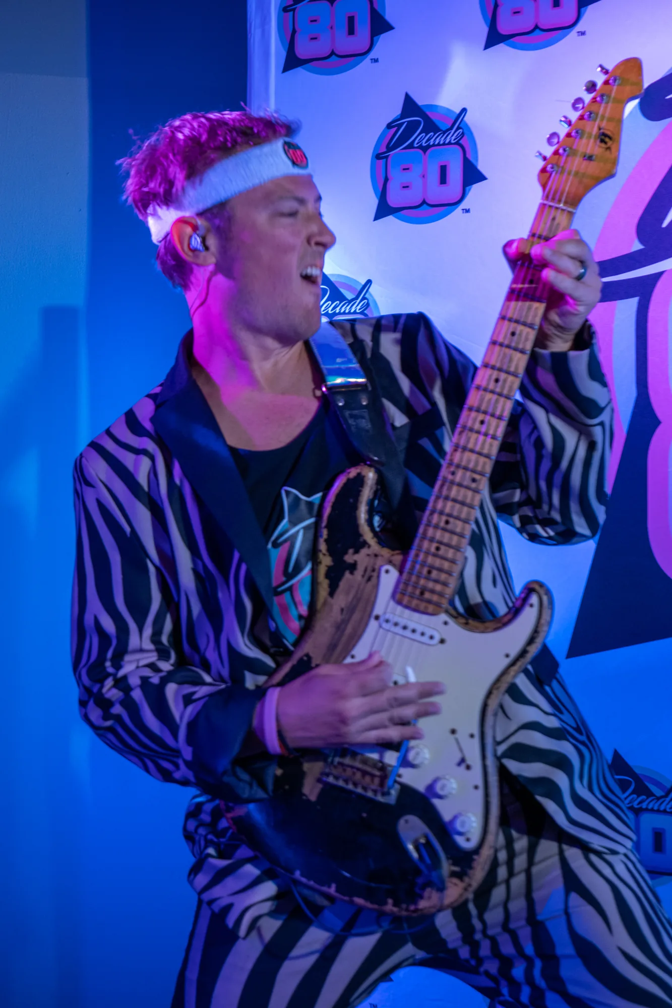 Decade80 guitarist rocking out in a zebra jacket