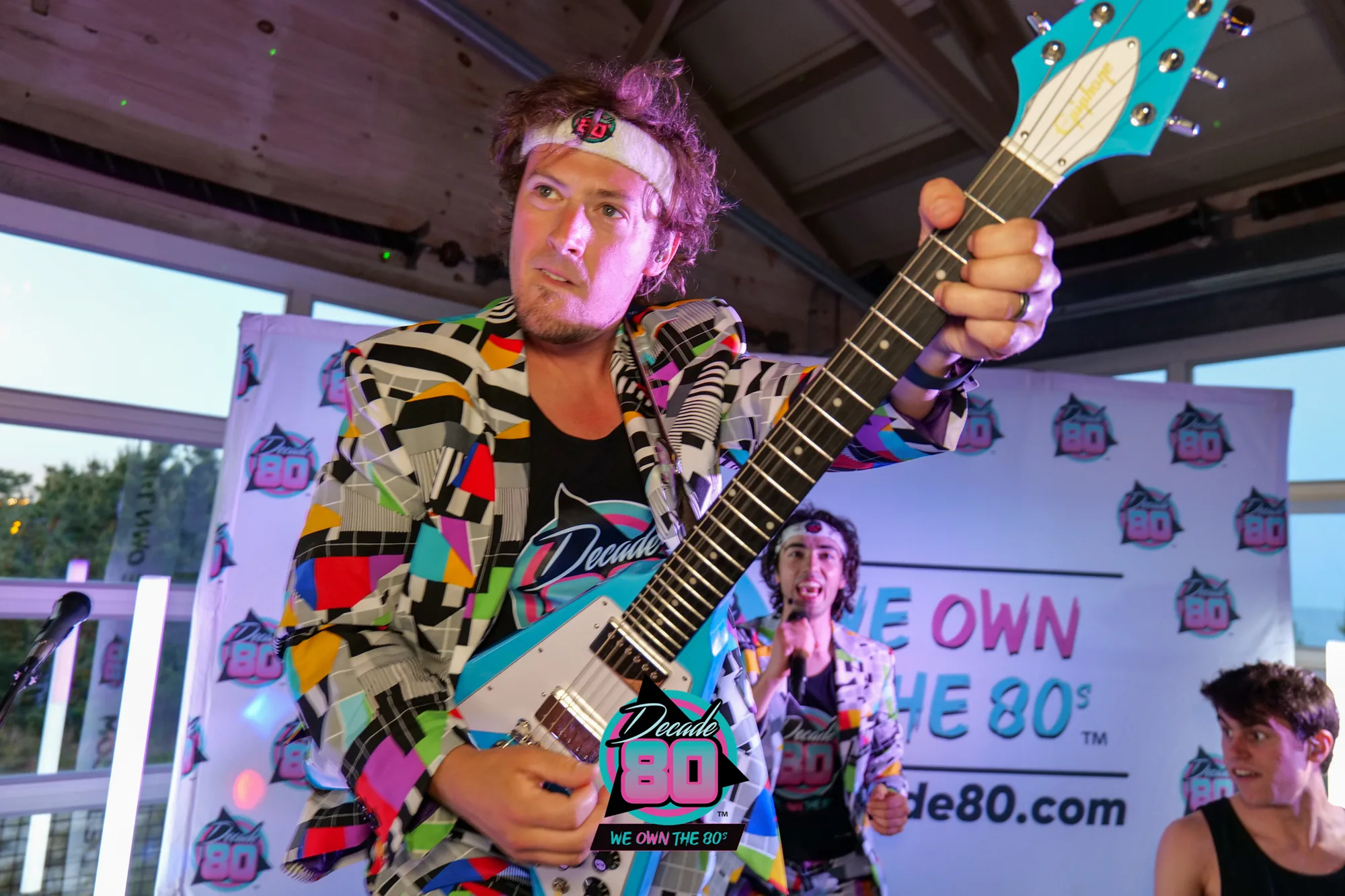 Decade80 guitarist performing outdoors in a geometric jacket